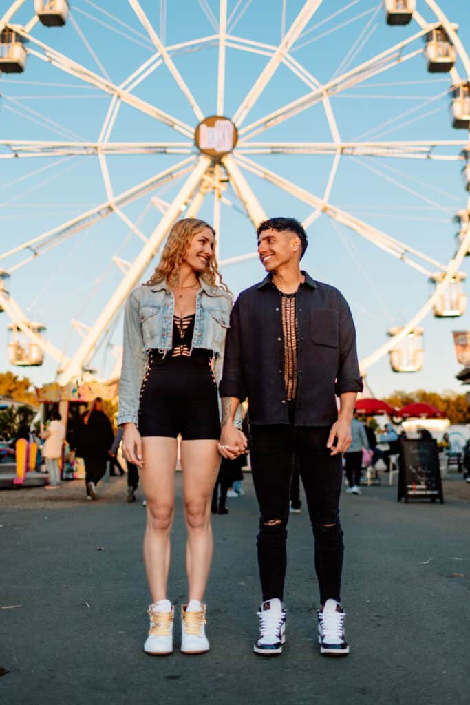 Bunte und emotionale Paarfotos auf einem Jahrmarkt in Berlin bei Sonnenuntergang, im Hintergrund ein Riesenrad