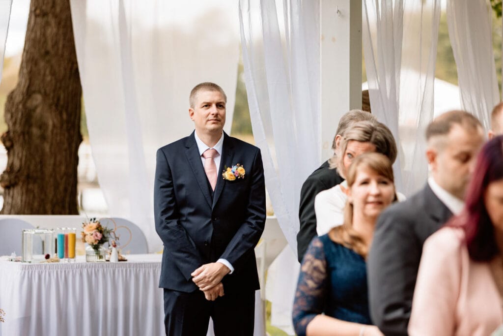 Bräutigam steht am Altar und erwartet seine zukünftige Ehefrau. Hochzeitsreportage Brandenburg