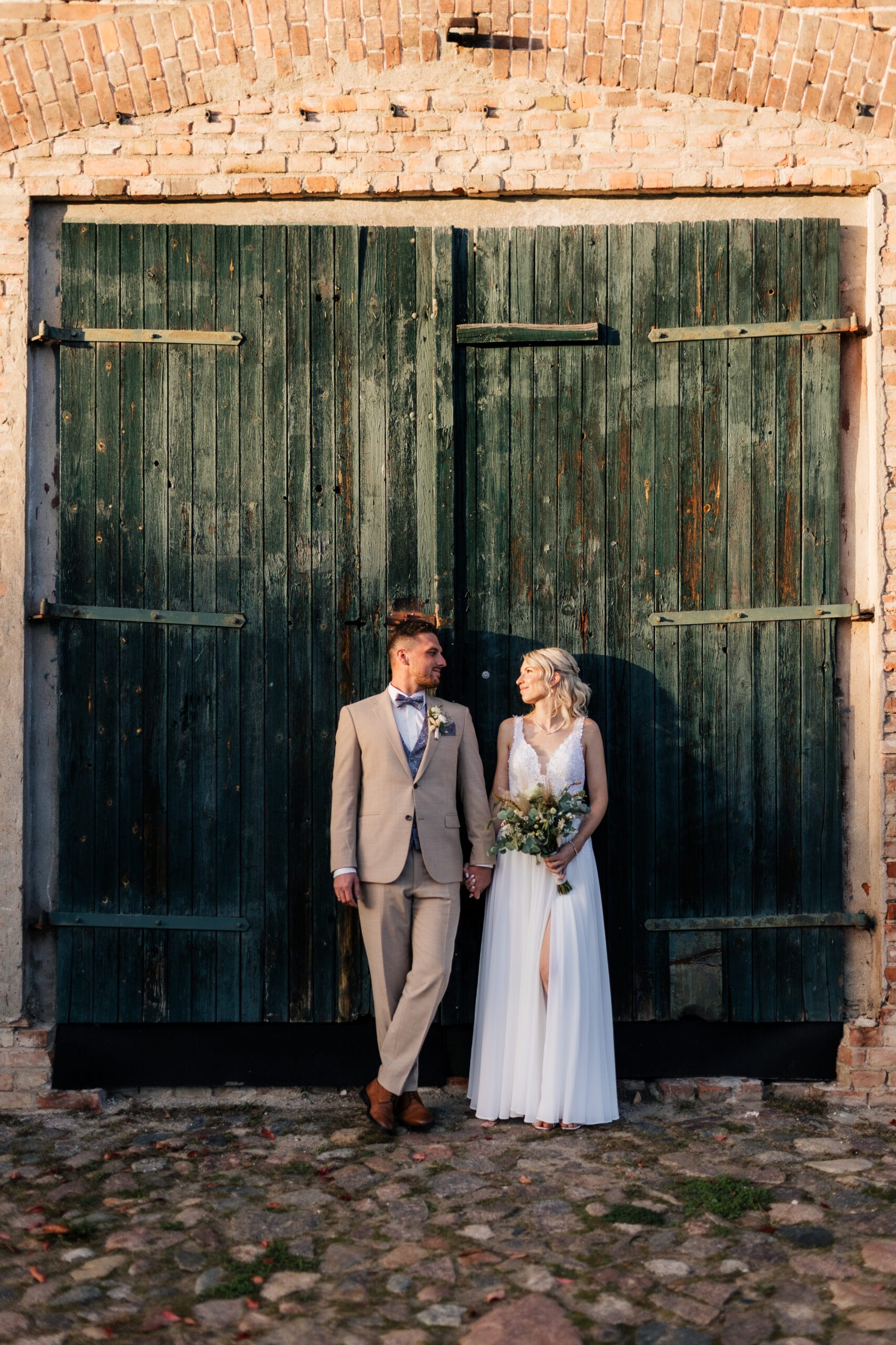 Hochzeuitsfoto am Gutshof Liepe in Brandenburg, das Paar schaut sich verliebt an